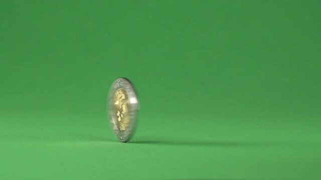 A coin of 5 Mexican pesos spinning on a chroma background.