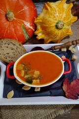 Pumpkin cream soup.  Tasty and nutritious pumpkin soup in white bowl and croutons and puff pastry - selective focus