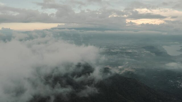 Drone aerial flying high over clouds, landscape view of Guatemala lake Amatitlan