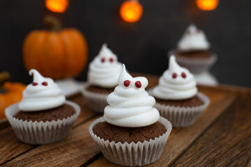 Halloween ghost cupcakes , homemade sweet chocolate muffins with meringue ghost