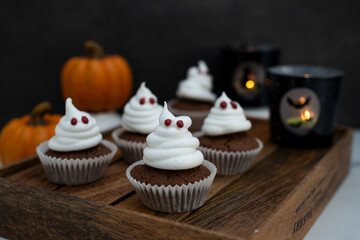 Halloween ghost cupcakes , homemade sweet chocolate muffins with meringue ghost