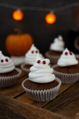Halloween ghost cupcakes , homemade sweet chocolate muffins with meringue ghost