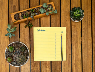 notepad on a table with succulents around