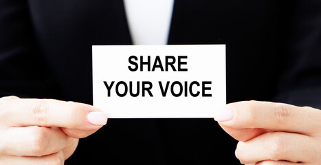 businesswoman holding a card with text SHARE YOUR VOICE