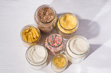 Variety of grains, pasta and candies in glass jars, top view. Zero waste storage concept. Foods storage in kitchen at low waste lifestyle
