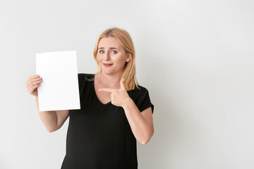 Naklejka premium Woman with blank paper sheet on grey background