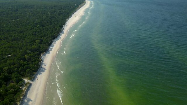 Tilt up from the turquoise tropical Osetnik beach waters with white sand to the sky, Poland