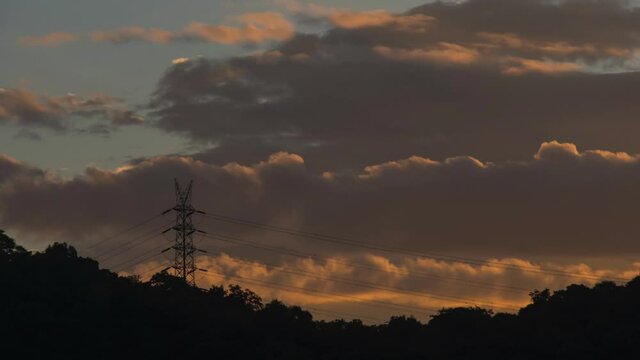 morning goldern clouds moving behind the mountain and electrical tower