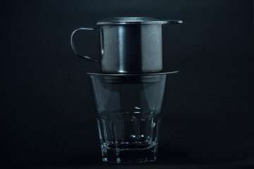 Vietnamese coffee drip on wooden planks with black background
