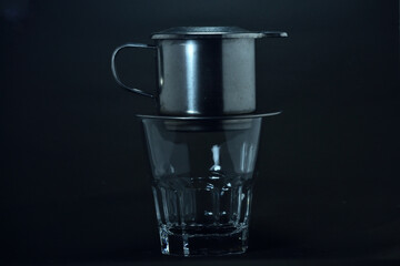 Vietnamese coffee drip on wooden planks with black background