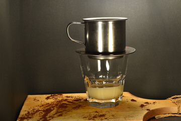 Vietnamese coffee drip on wooden planks with black background