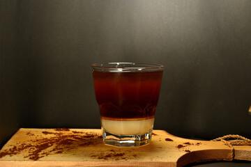 black coffee with creamer at the bottom of the glass