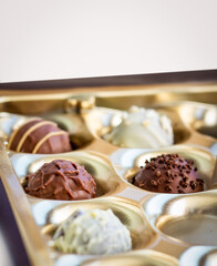 a box of round belgian or swiss chocolate candies close up, praline for confectionery advertising 