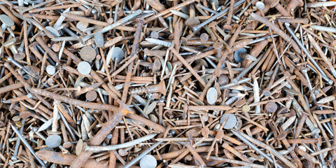 old rusty spikes and used metal nails in flat lay background