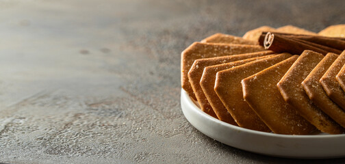 Cinnamon sugar  crackers on white plate on large concrete background for banner