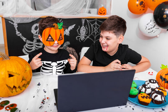 Happy Young Boys, Brothers Talking With Grandparents Via Video Call Using Laptop On Halloween Day , Excited Kid Showing His New Mask For Halloween On Camera