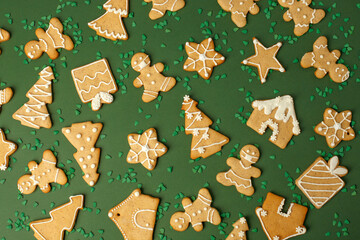Winter Holiday pattern - set of gingerbread on ltraditional green background - man in mask, house,...