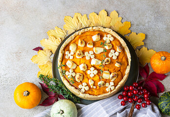 Top view of pumpkin tart or pie with feta cheese and thyme. Fall season concept. Cozy autumn food background.