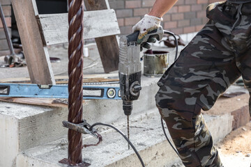 A worker bolts a metal pole to concrete