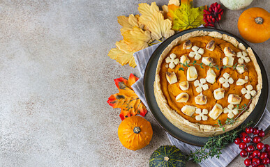 Top view of pumpkin tart or pie with feta cheese and thyme. Fall season concept. Cozy autumn food background.