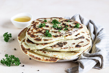 Indian homemade traditional flatbread with fresh parsley and olive oil. Chapati, roti or naan Indian crispy flatbread.