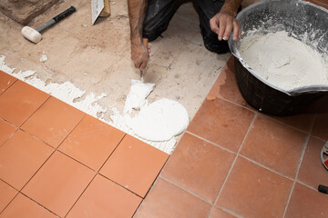 bricklayer worker laying tiles on floor