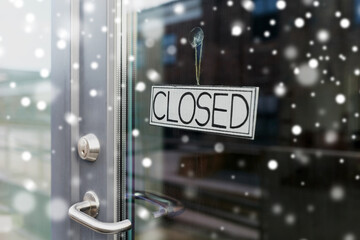 small business, pandemic and service concept - glass door of closed shop or office in winter over snow