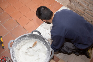 bricklayer worker laying tiles on floor