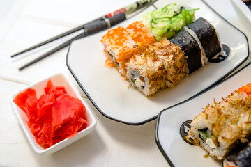 Several sushi on a white plate standing on a white background
