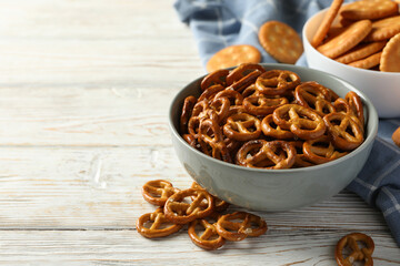 Napkin and bowls with cracker biscuits on wooden background