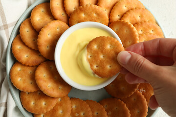 Napkin and plate with cracker biscuits and cheese sauce on white - light beige background
