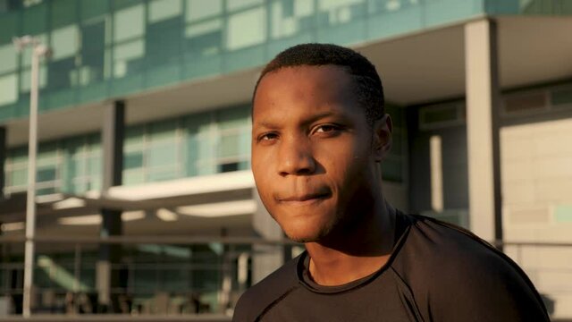 Portrait of handsome african american male athlete in sportswear resting on a sunny afternoon. Close-up. Young black man looking at camera outdoors. 