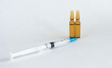 Medical ampoule and syringe, vaccine and syringe on a white background. Medical glass bottle with copy space, with syringes. Seasonal illness concept. Two vials for medical injection