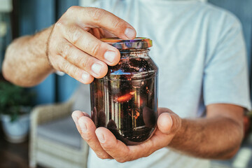 jar of peach jam in men's hands, canning.