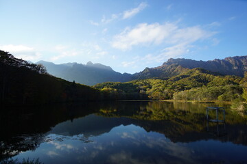A pond that reflects trees and mountains like a mirror. At dusk. Beautiful scenery of Japan.