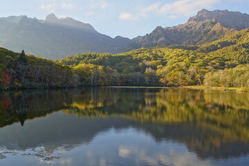A pond that reflects trees and mountains like a mirror. At dusk. Beautiful scenery of Japan.