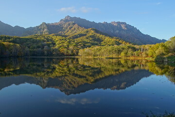 Naklejka na ściany i meble A pond that reflects trees and mountains like a mirror. At dusk. Beautiful scenery of Japan.