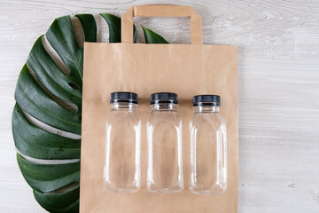 Three plastic bottles on a brown paper eco bag. Place for your logo. Eco-friendly food packaging...