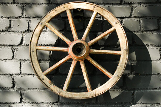 Old wheel hanging on black wall