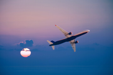 airplane flight against the sunset sky, aviation and travel concept