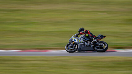 A panning shot of a racing bike cornering on a track.