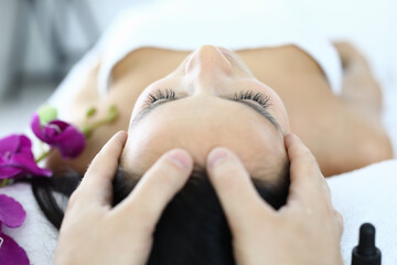 Obraz na płótnie Canvas Masseur's fingers lie on woman's face. Rejuvenating facial massage concept