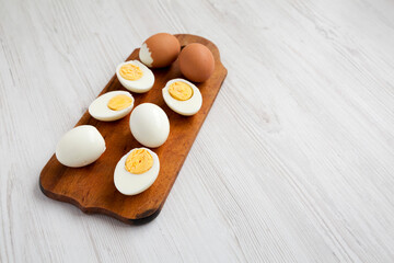 Hard Boiled Eggs on a rustic wooden board, side view. Copy space.