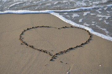 Cuore nella spiaggia mare calmo. Amore sulla sabbia