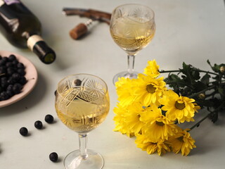 Two glasses for two.Still life with autumn yellow flowers, hresanthem, wine and dark blackthorn...