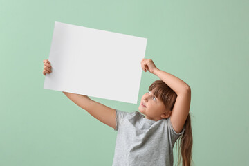 Little girl with blank paper sheet on color background