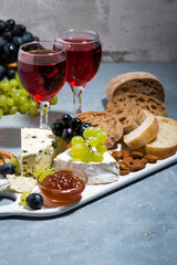 cheese plate, fresh ciabatta, grapes and two glasses of red wine