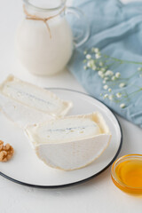 traditional cheese with white and blue mold in the section. Large pieces of sliced cheese on a light table