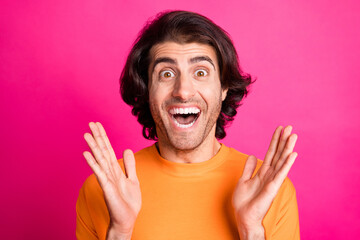 Photo of handsome young man hands face amazed look wear orange t-shirt isolated pink color background