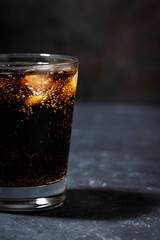 glass of coca cola with ice on a black background, vertical